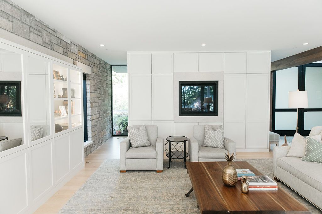 A living room with a couch , chairs , coffee table and television.