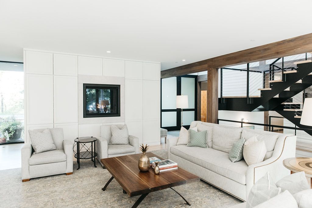 A living room with white furniture and a wooden coffee table.