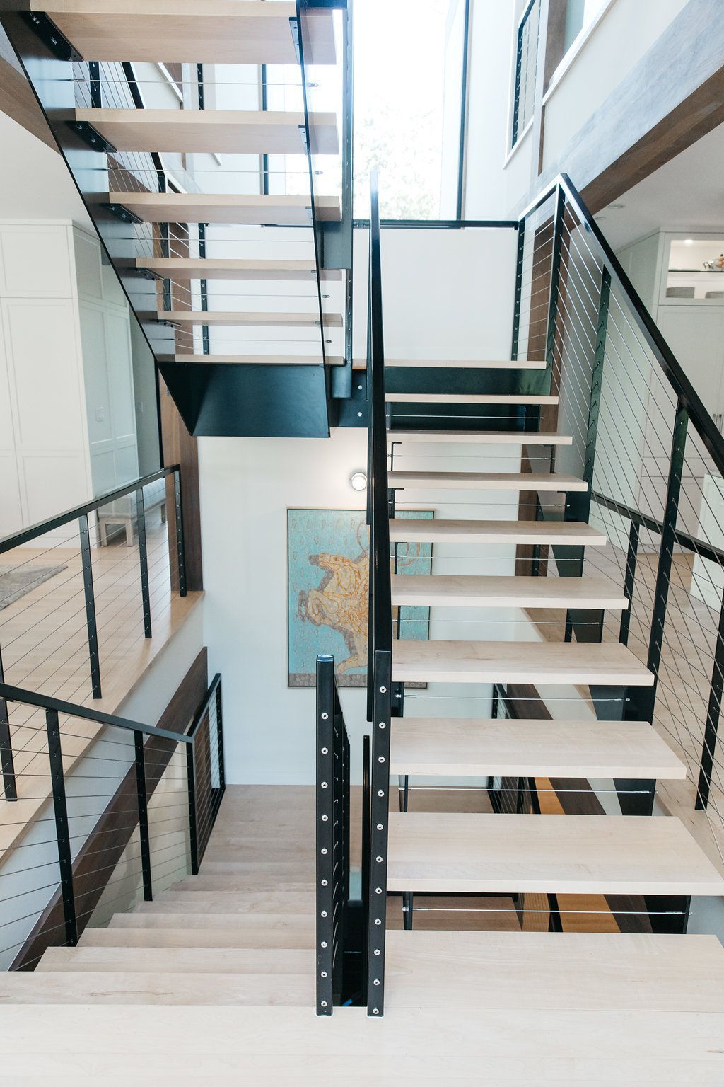 A wooden staircase with a metal railing in a house