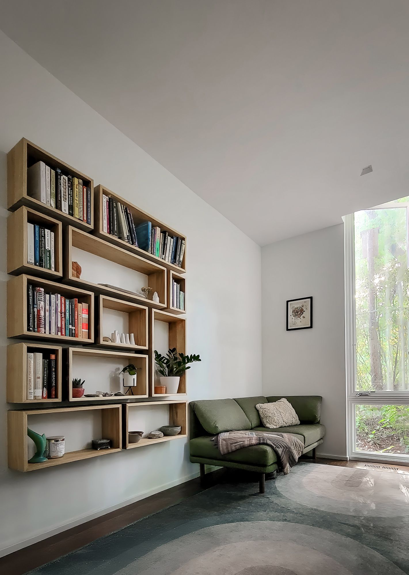 a living room with a couch, bookshelf, and window