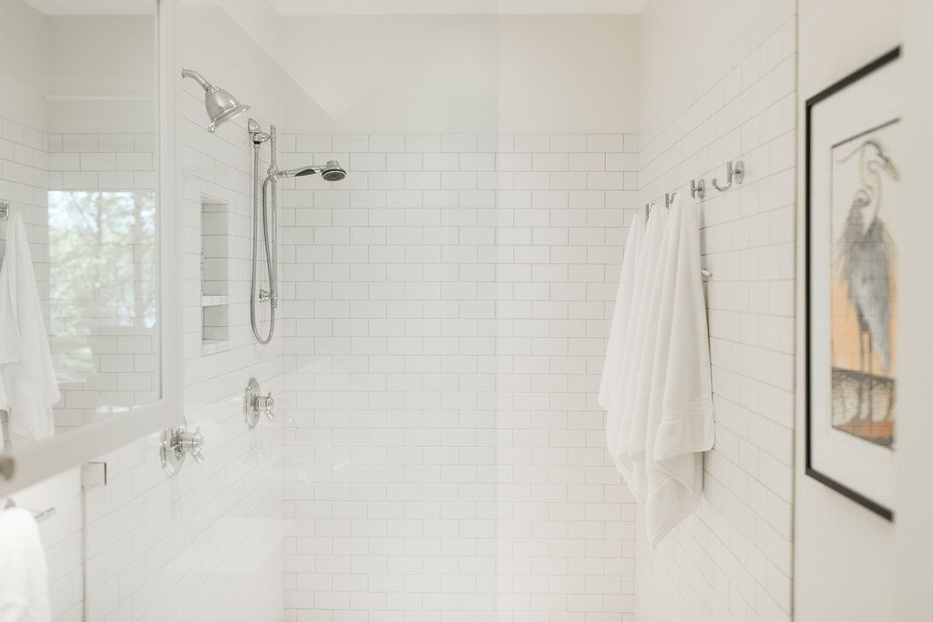A bathroom with a walk in shower and a picture on the wall.