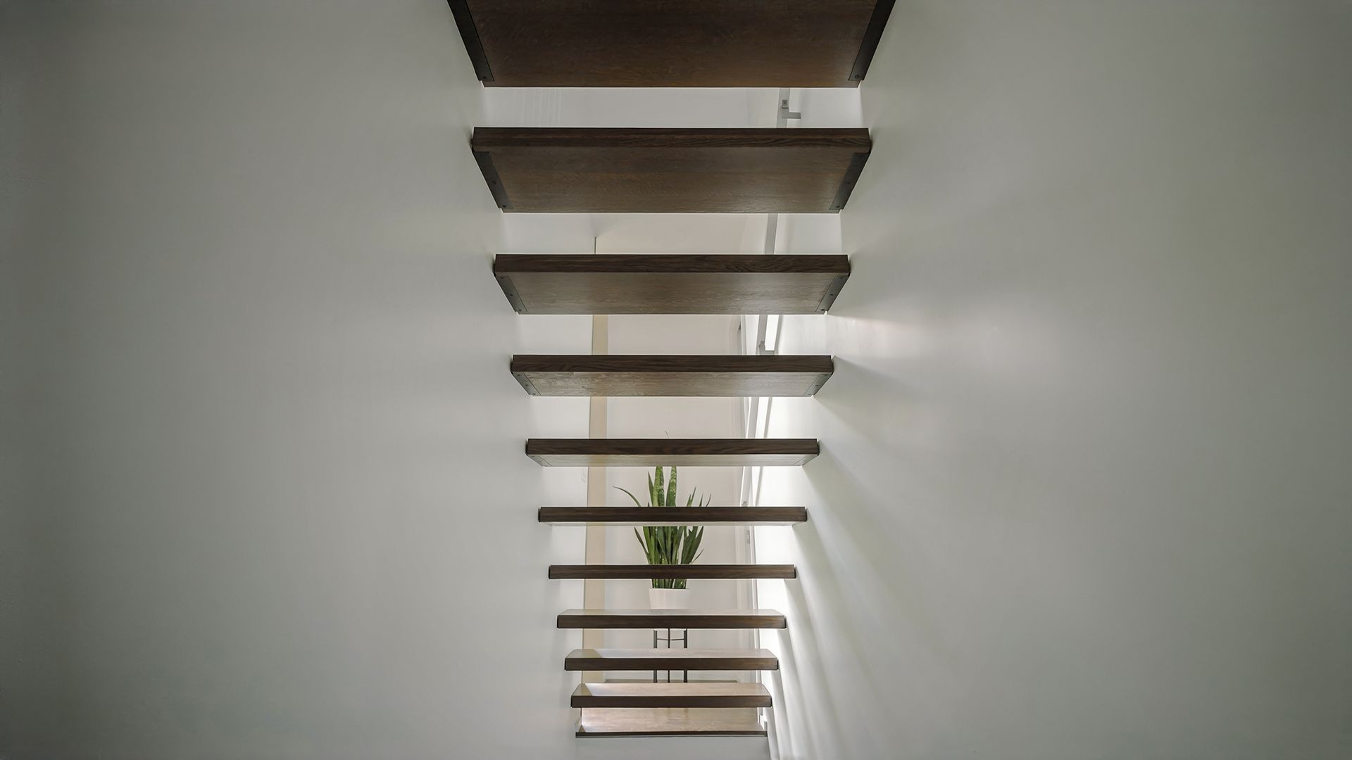 a wooden staircase leading up to a white wall in a house