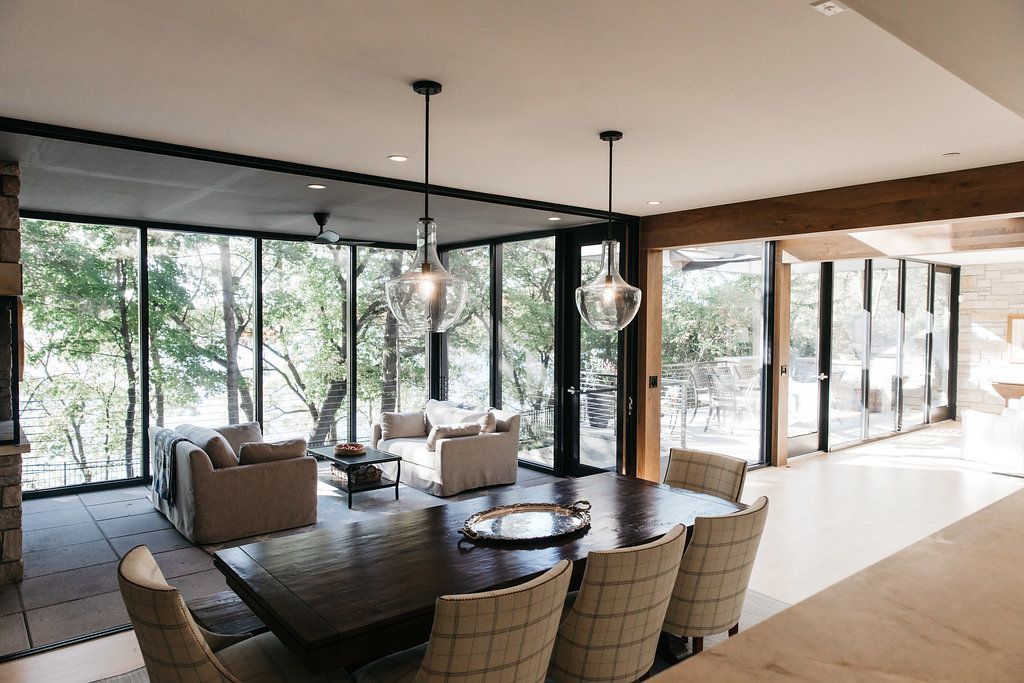 A living room with a table and chairs and a lot of windows