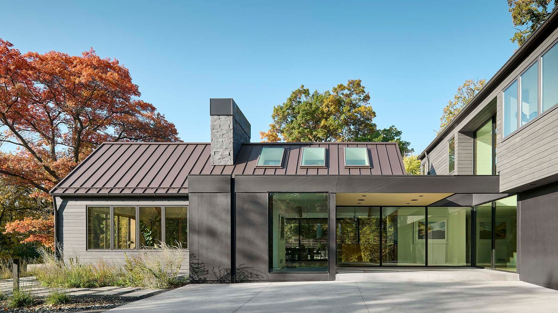 A large house with a lot of windows and a chimney on the roof.
