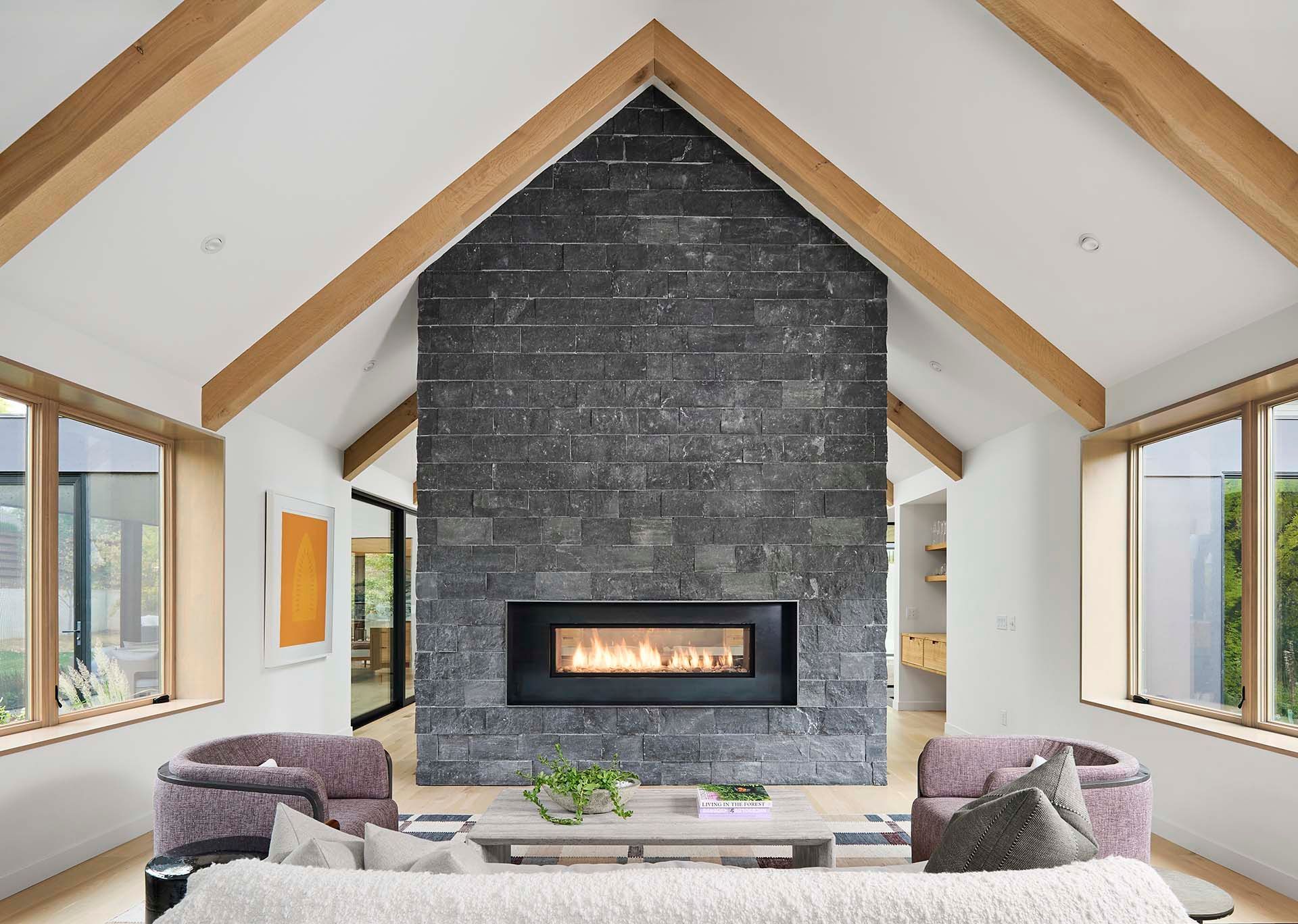 A living room with a fireplace and a vaulted ceiling
