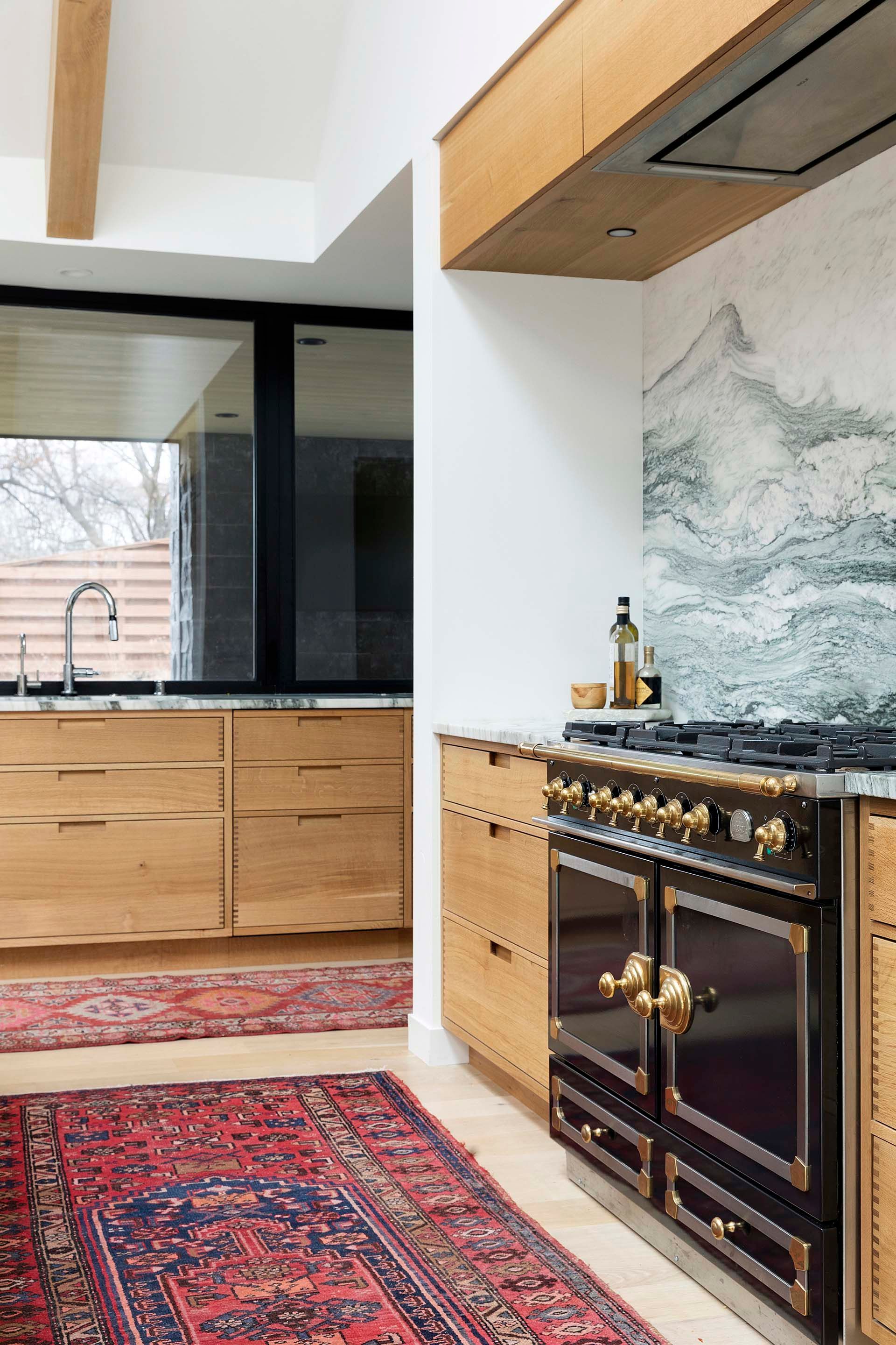 A kitchen with a rug on the floor and a stove.
