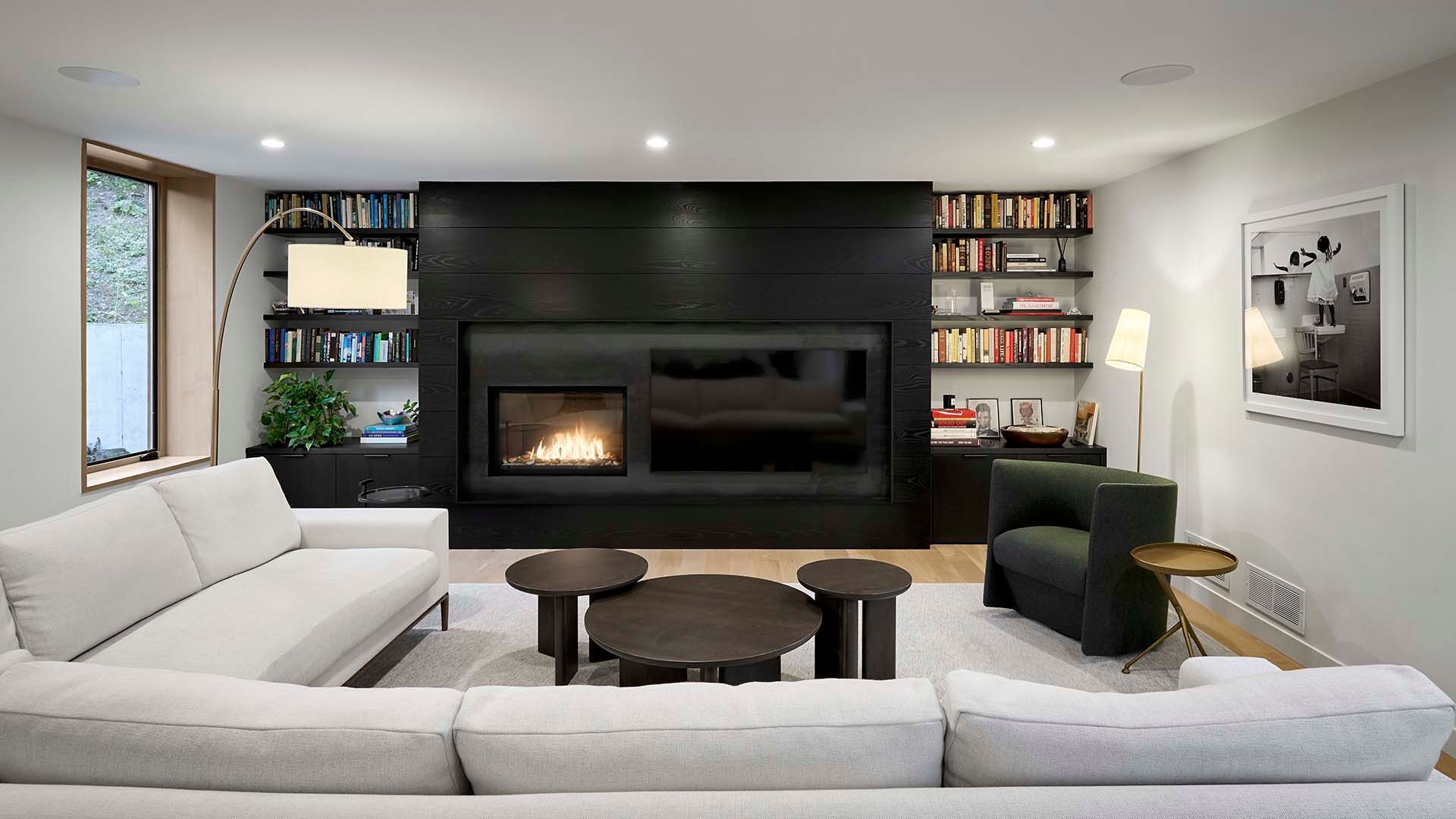 A living room with a couch , chairs , tables and a fireplace.