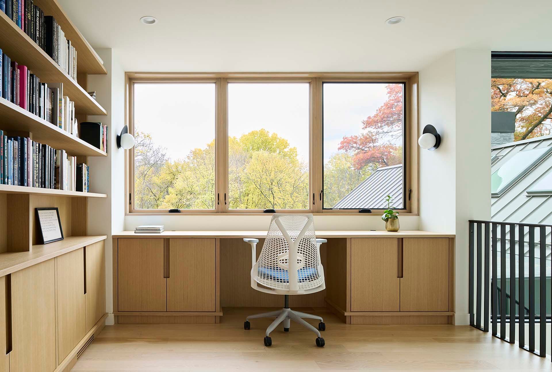 A home office with a desk and chair in front of a window.