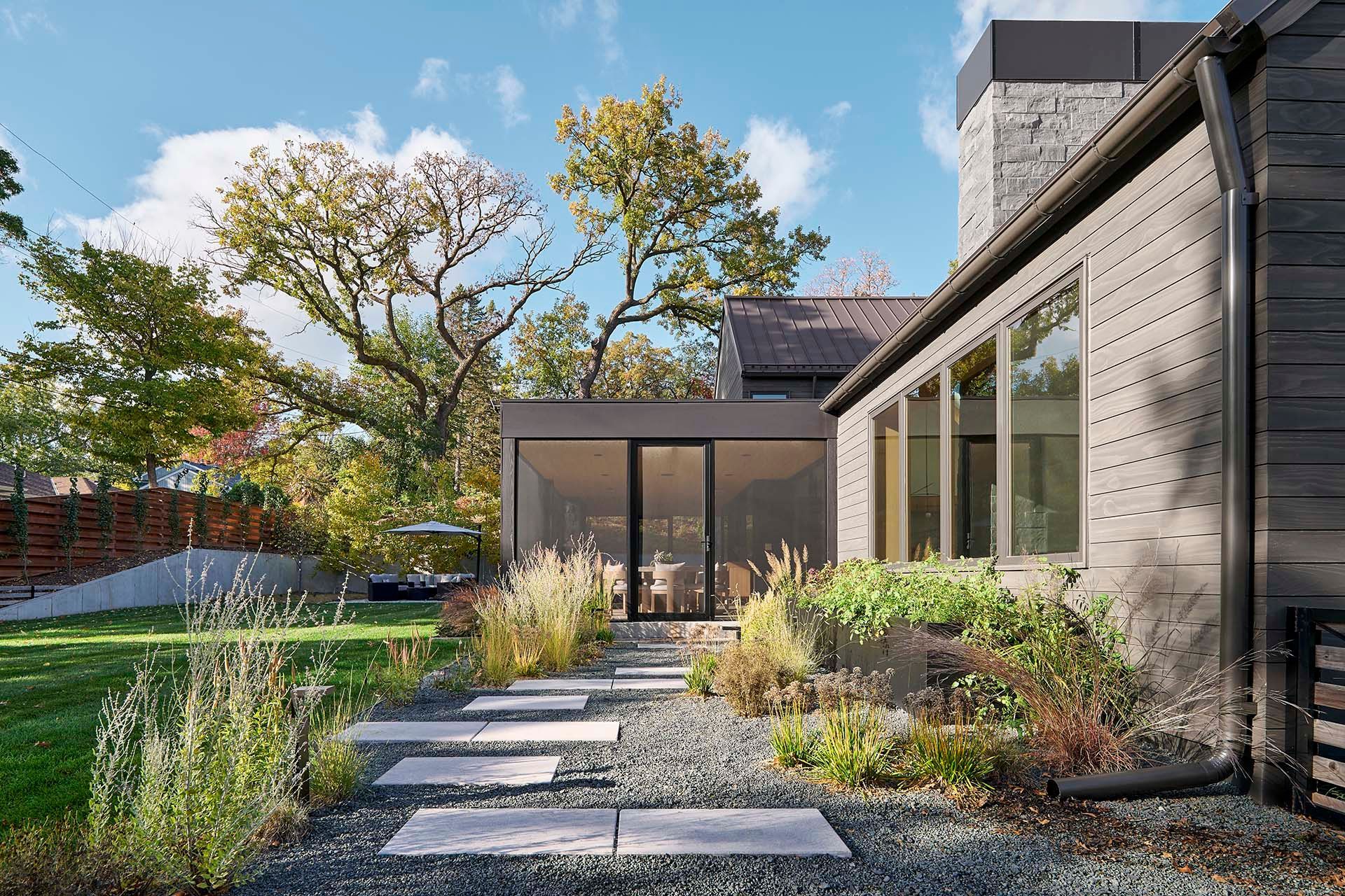 A house with a lot of windows and a walkway leading to it.