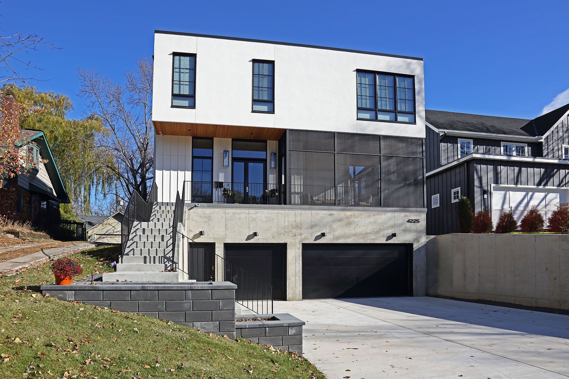 A large white house with a lot of windows is sitting on top of a hill.