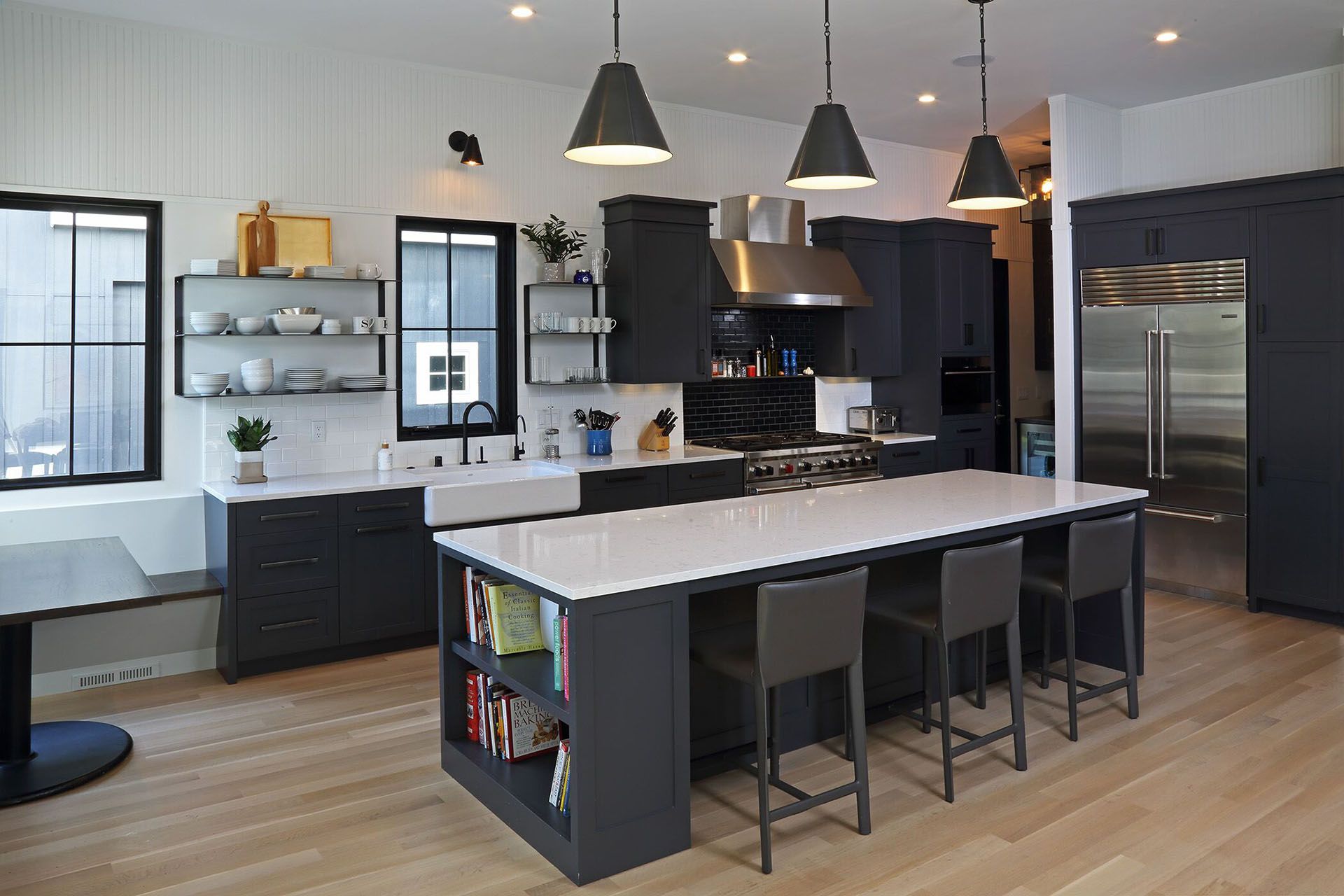 A large kitchen with black cabinets and white counter tops