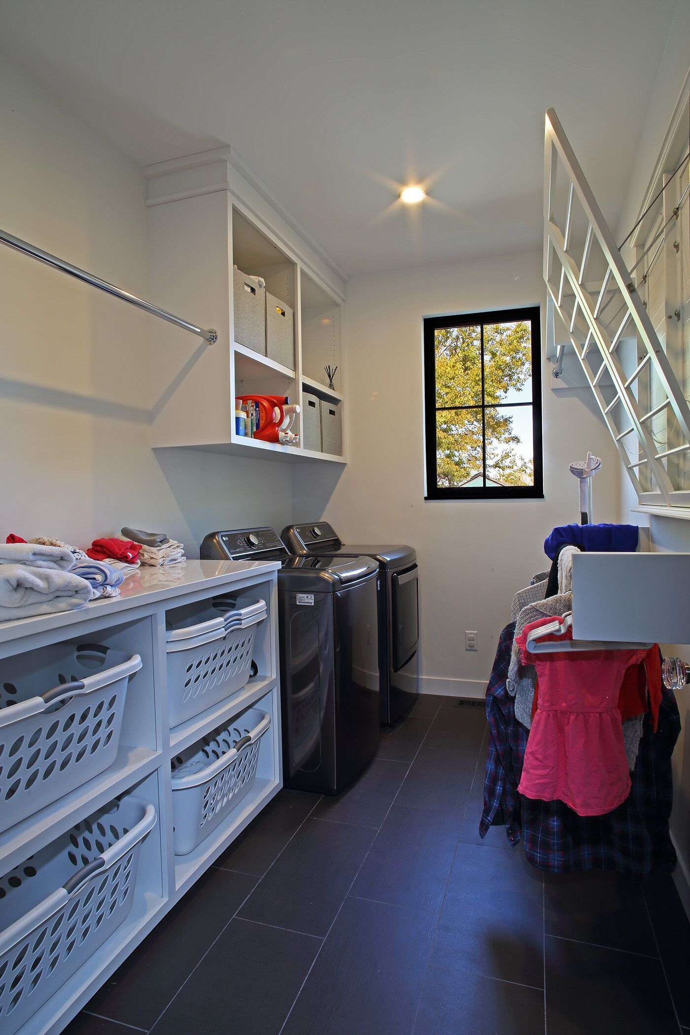 A laundry room with a staircase leading up to the second floor.