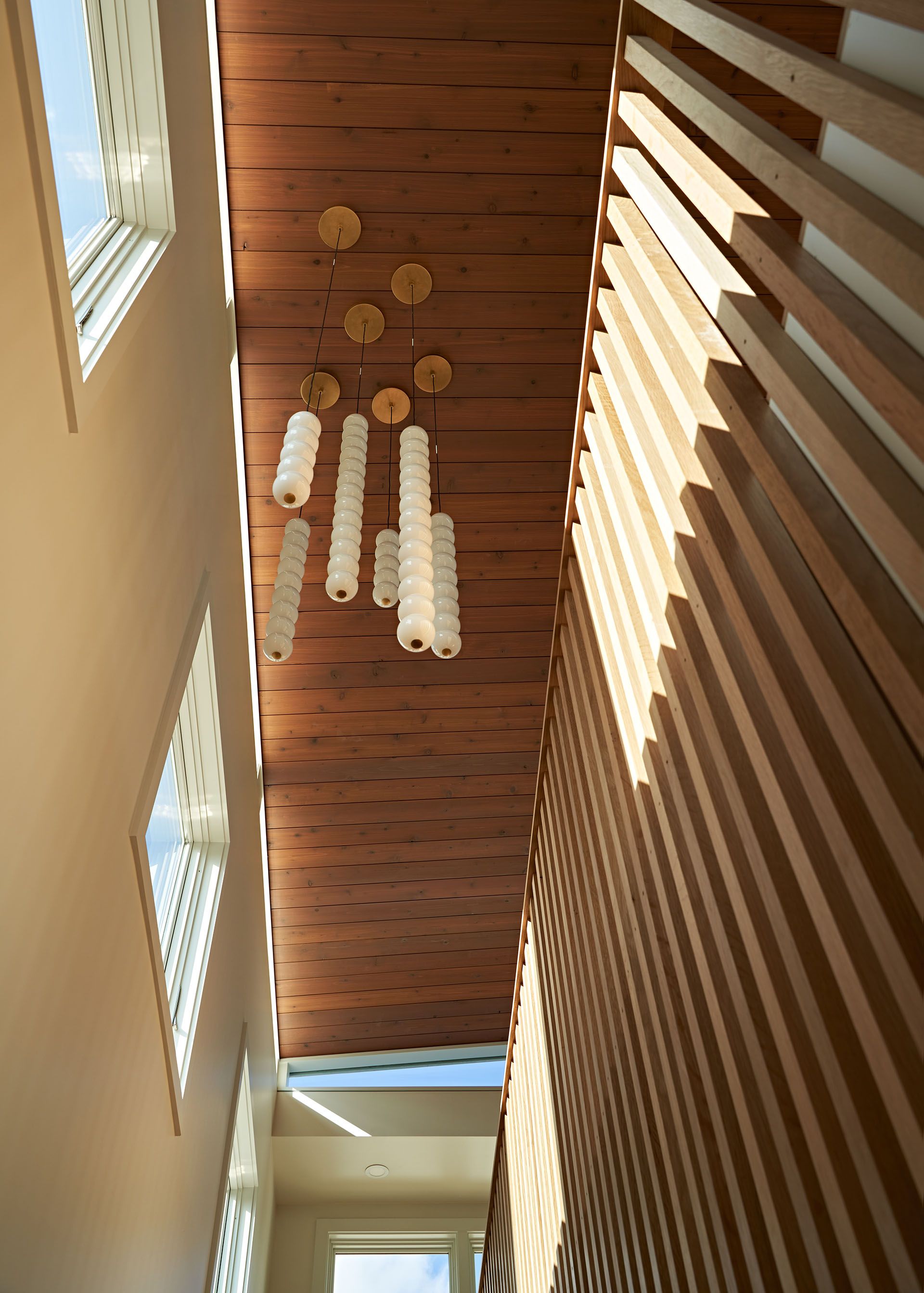 A hallway with a wooden ceiling and a chandelier hanging from it