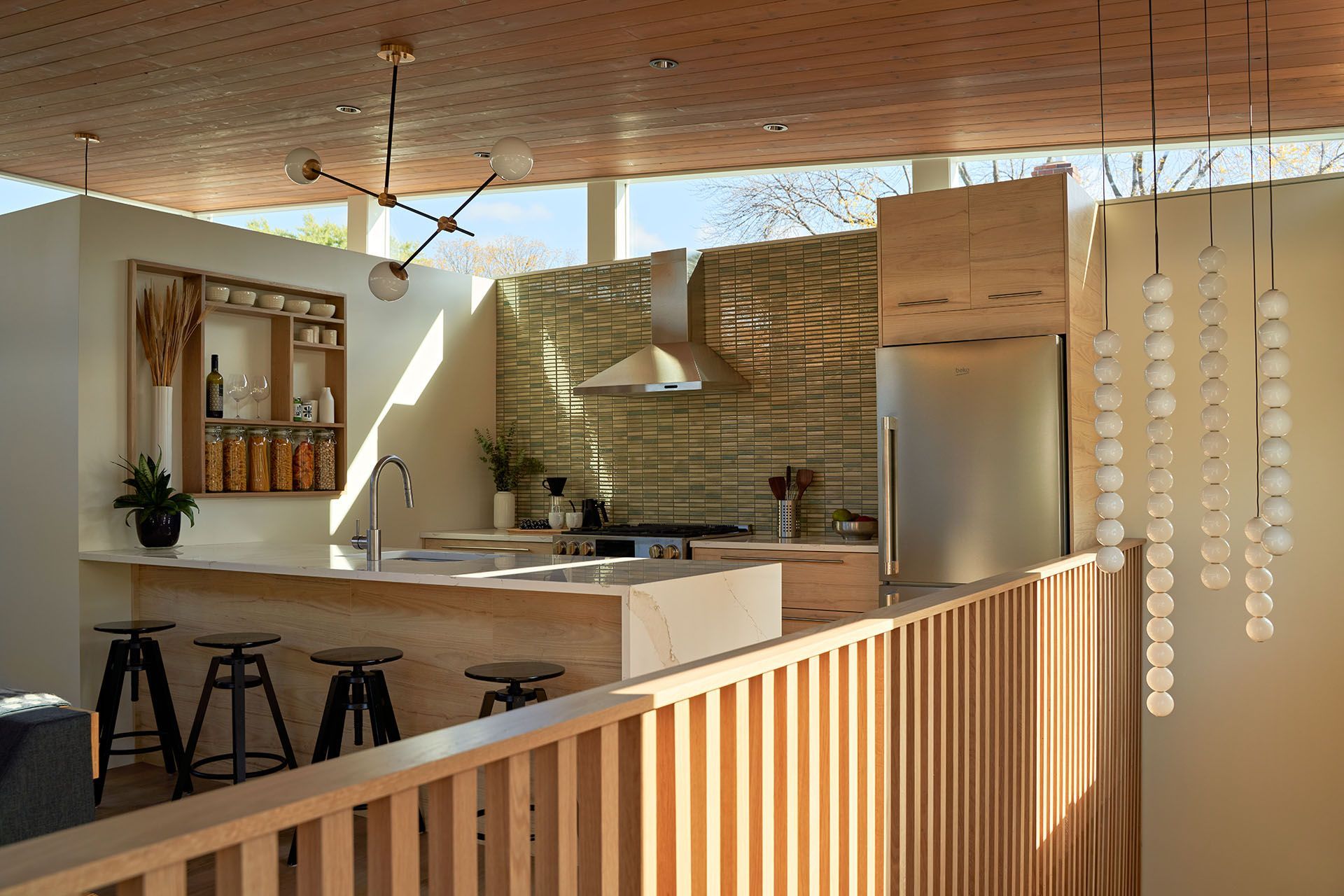 A kitchen with a wooden fence and stools