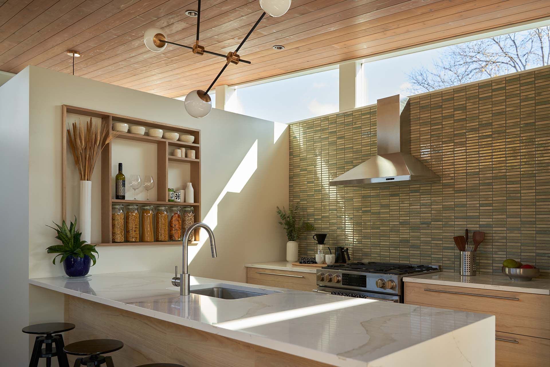 A kitchen with a sink , stove , and stools.