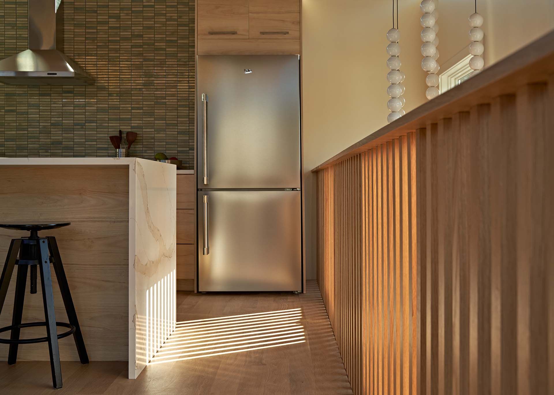 A kitchen with a stainless steel refrigerator and wooden cabinets