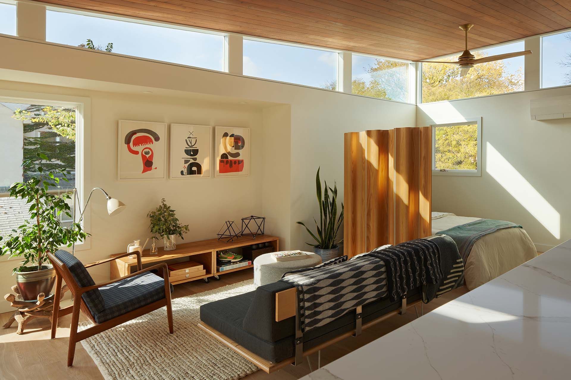 A living room with a couch , chairs , and a bed.