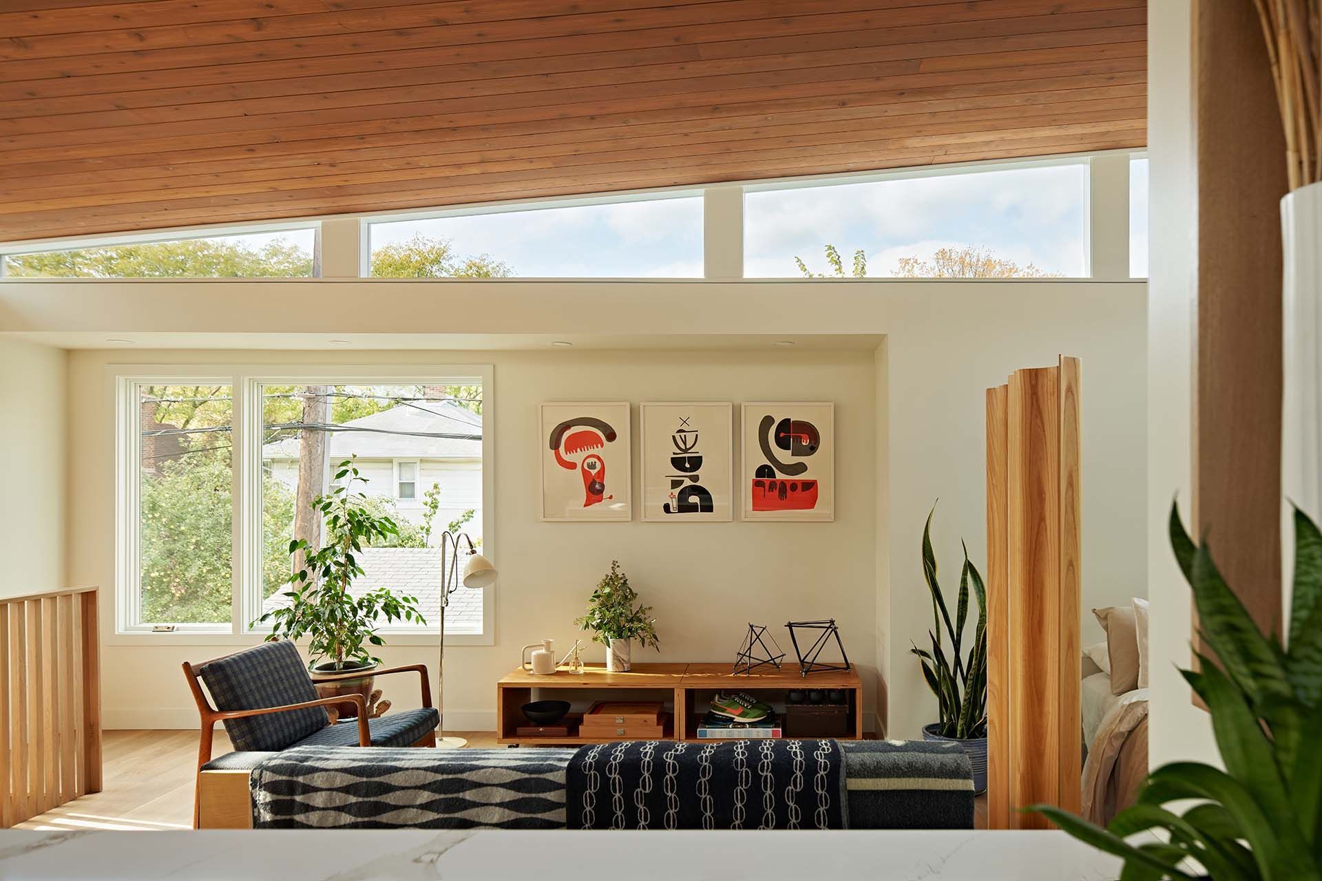 A living room with a lot of windows and a wooden ceiling.
