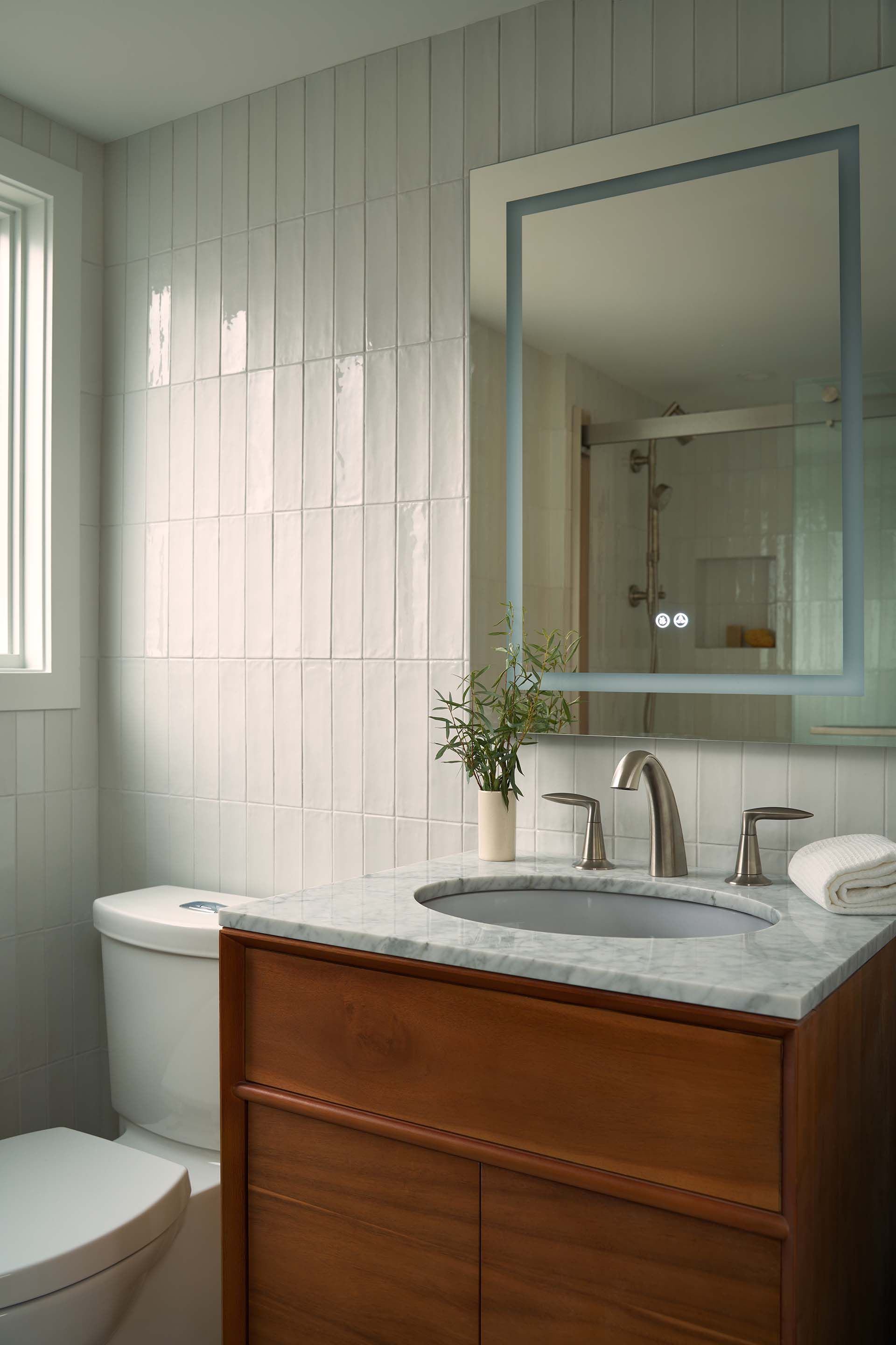 A bathroom with a sink , toilet and mirror.