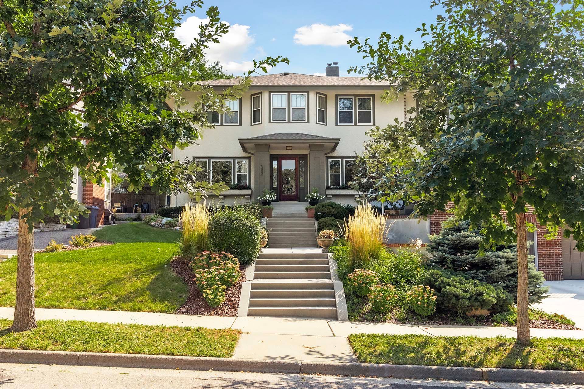 A large white house with stairs leading up to the front door