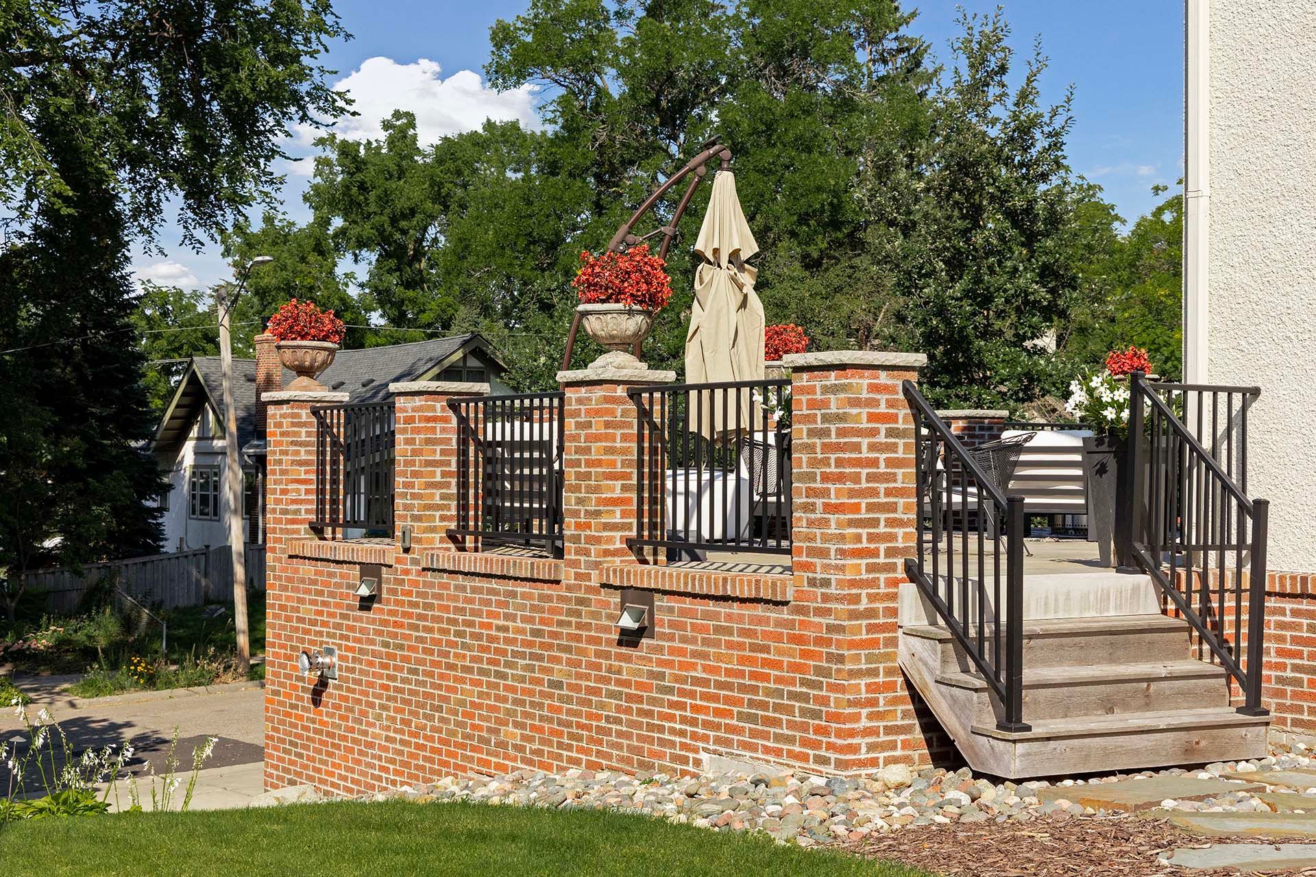A brick wall with stairs leading up to a deck