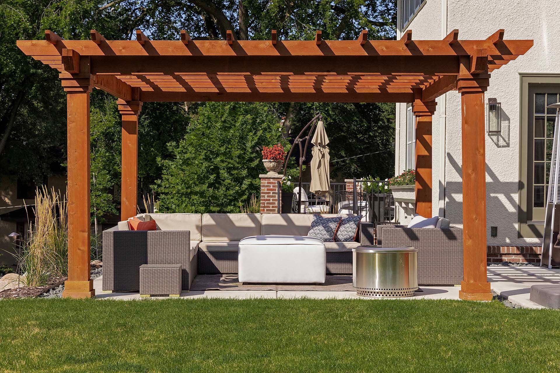 A wooden pergola with a couch underneath it