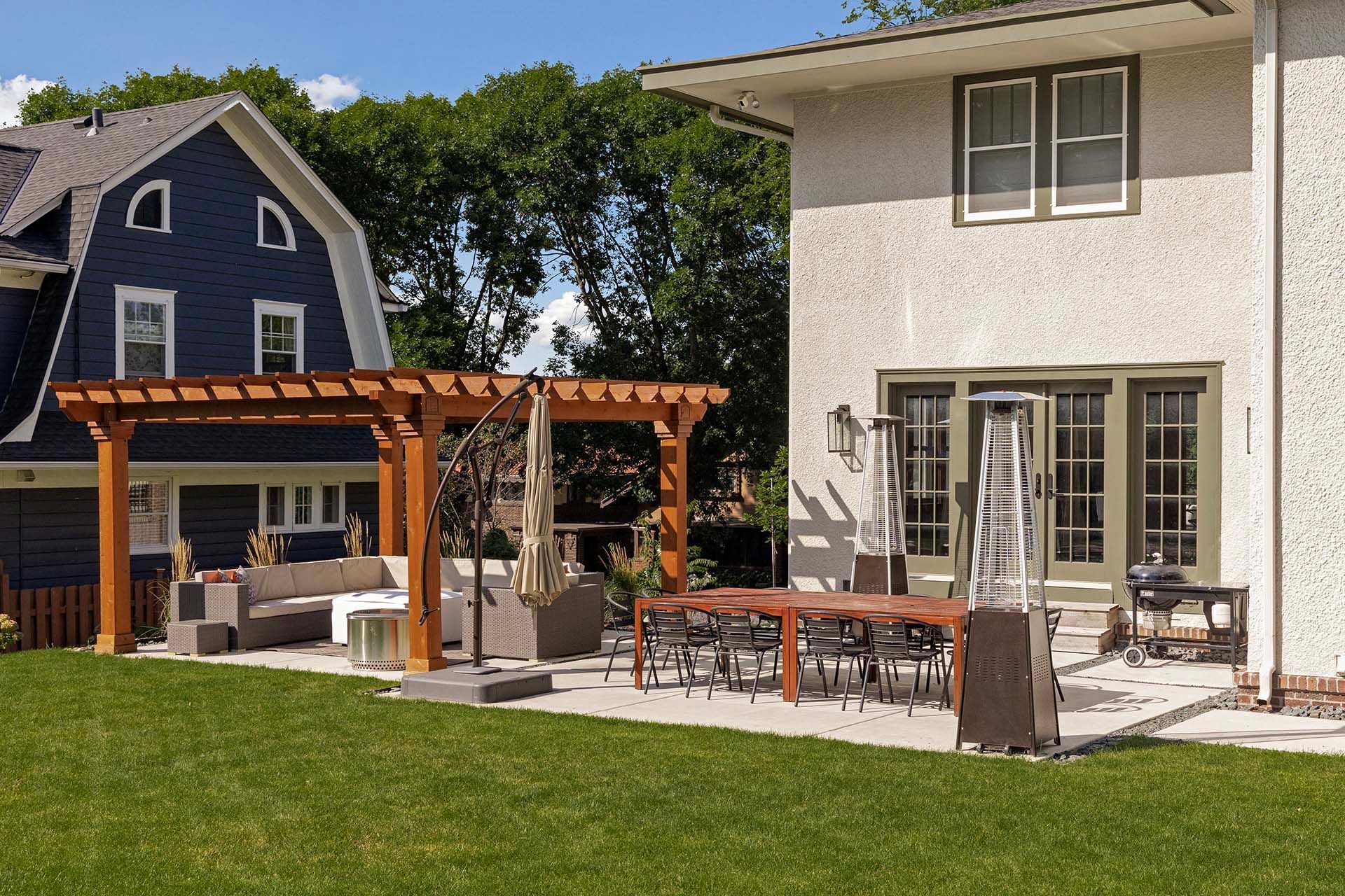 A house with a pergola and a patio in front of it