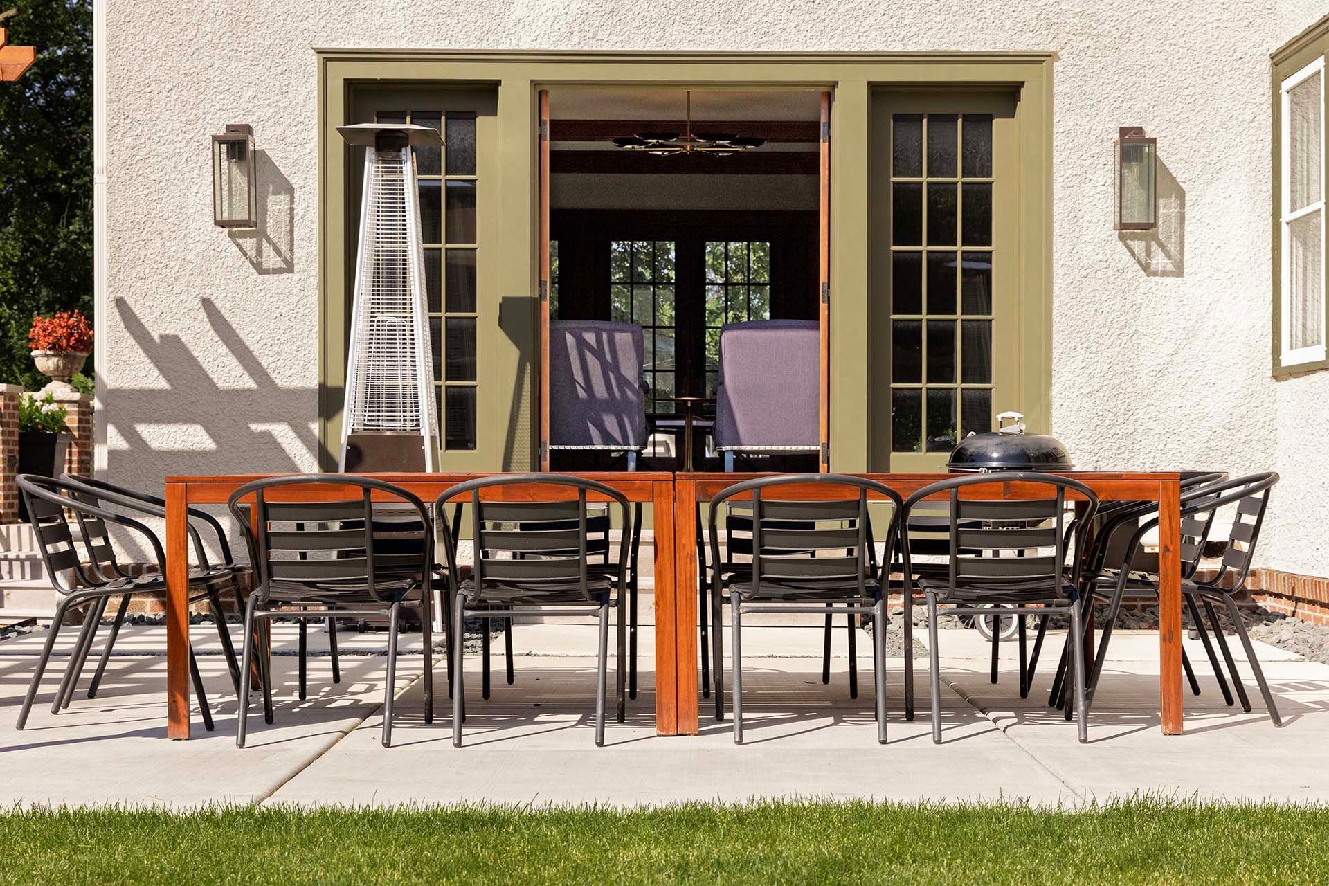 A patio with a table and chairs in front of a house