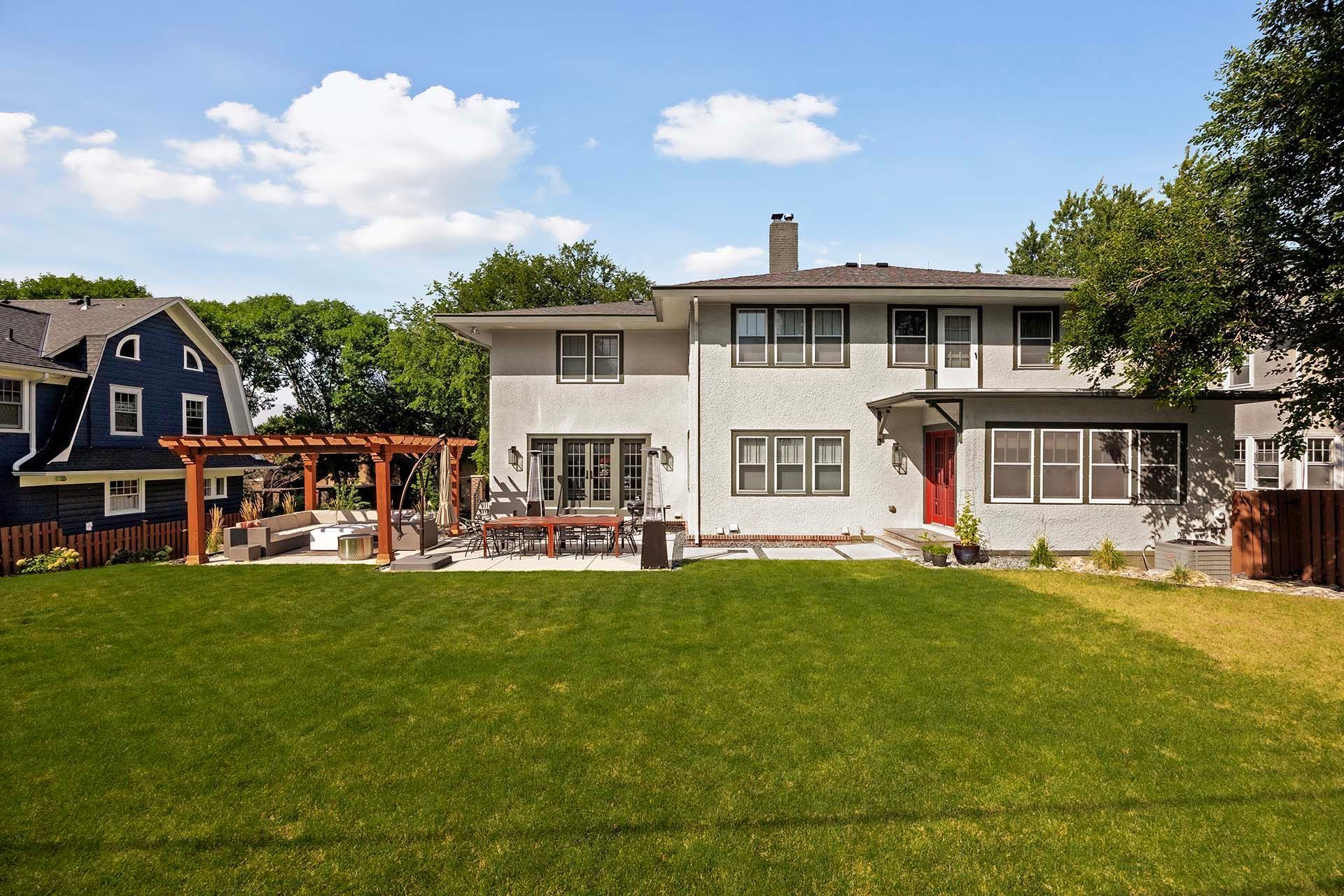 A large white house with a large lawn in front of it.