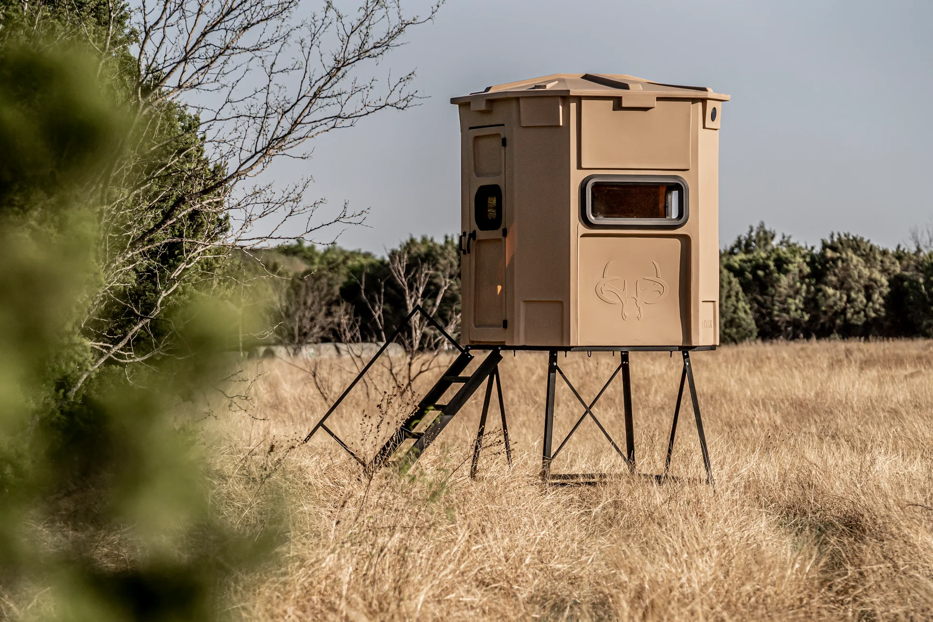 A hunting blind is sitting in the middle of a field.