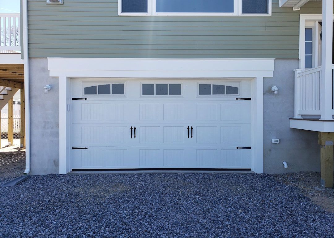 A white garage door is on the side of a house