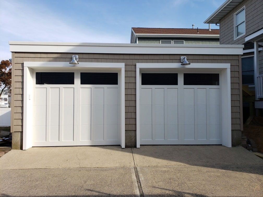 A house with two garage doors that are white