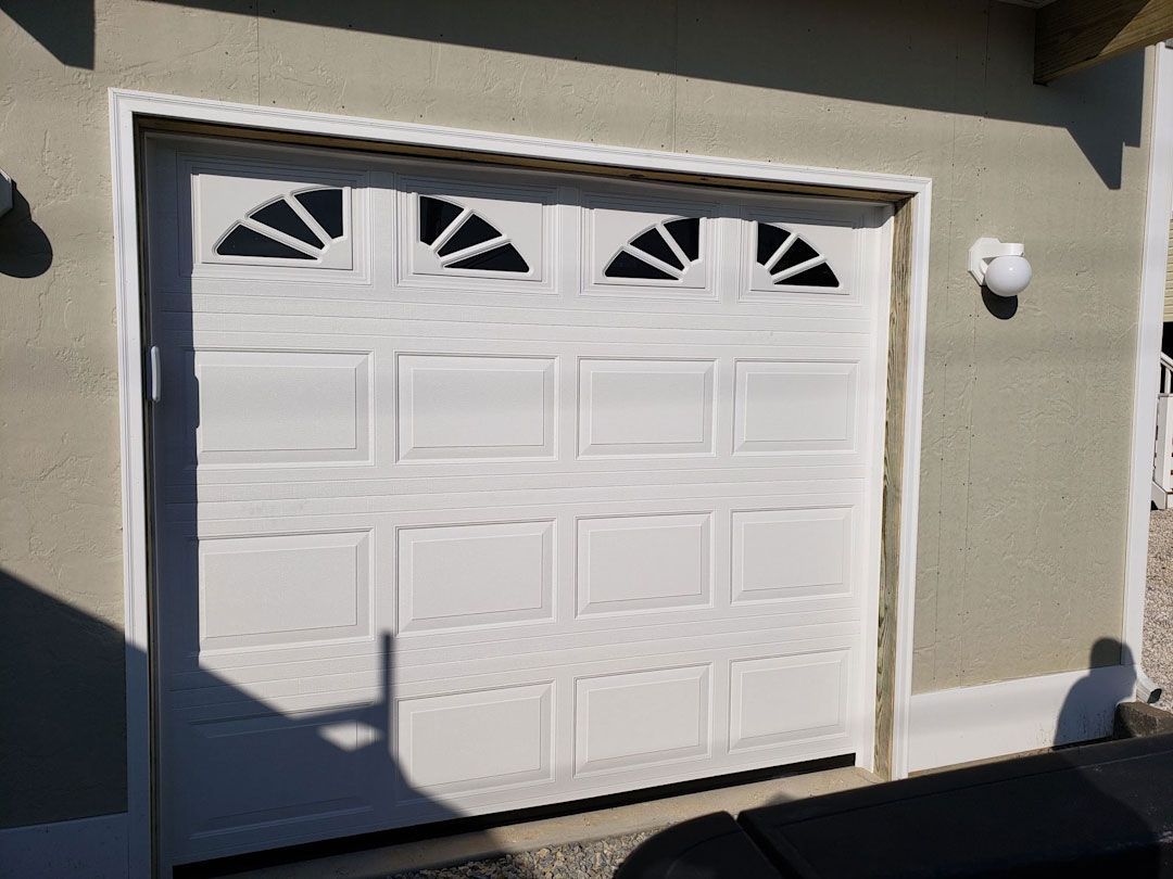 A white garage door with a light on the side of it.