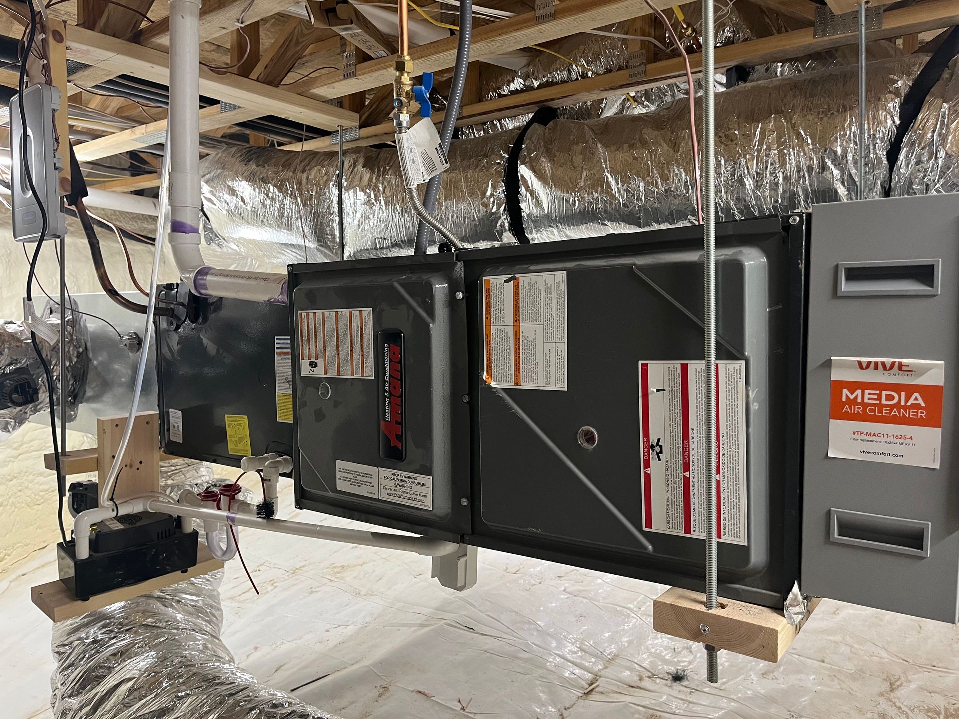 An air conditioner is hanging from the ceiling in a basement.