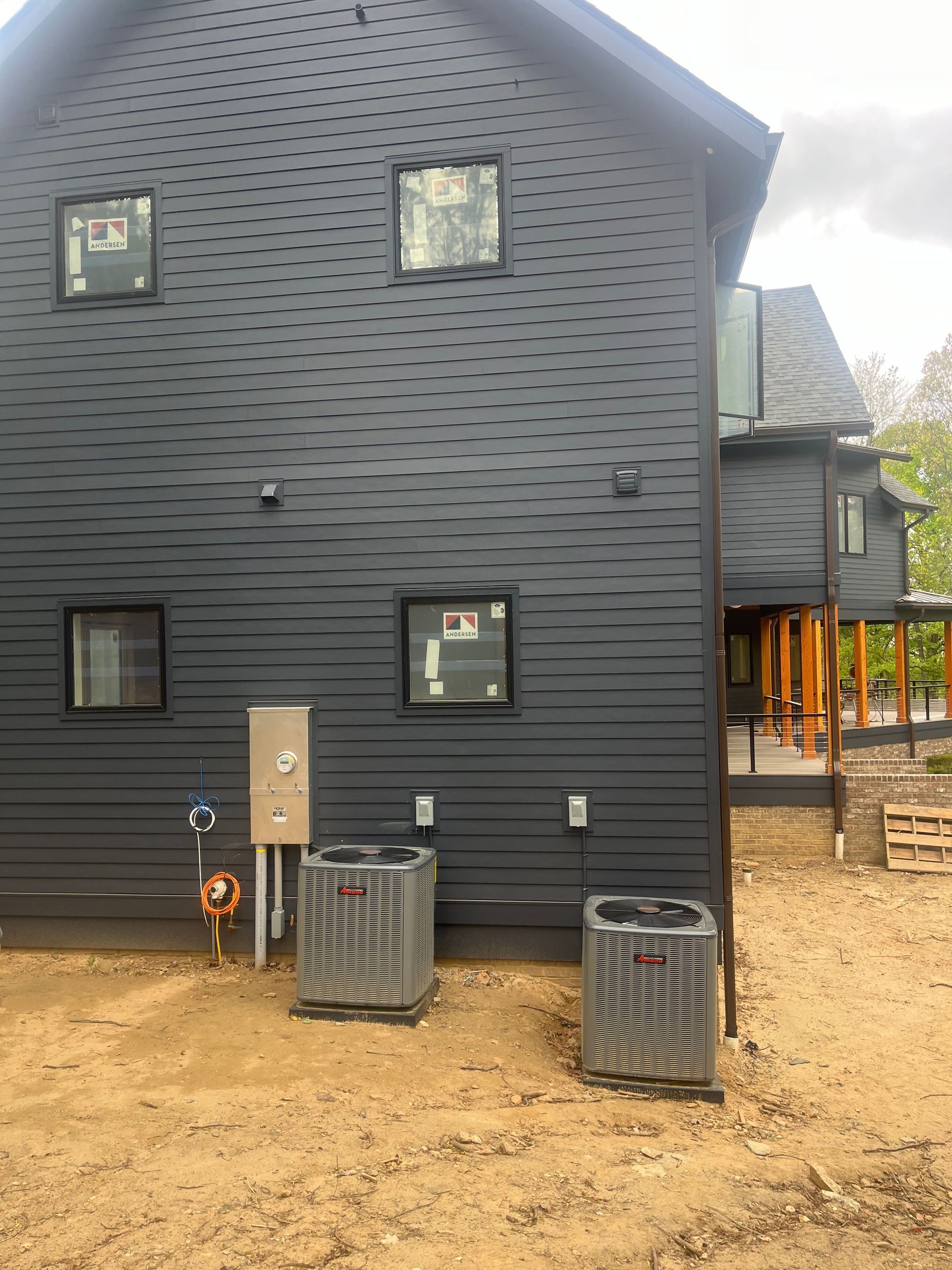 A black house with two air conditioners in front of it