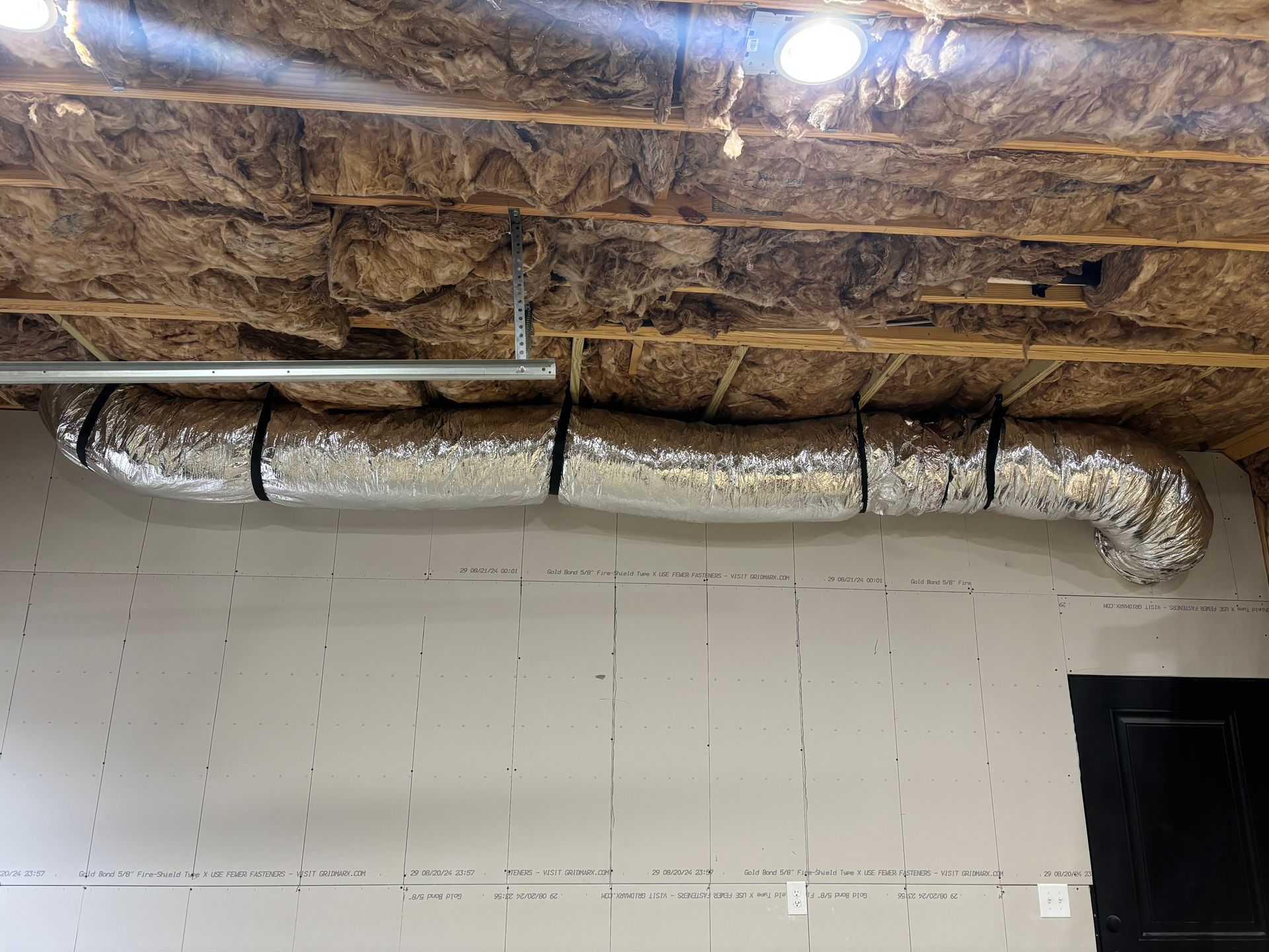 A large duct is hanging from the ceiling of a room.