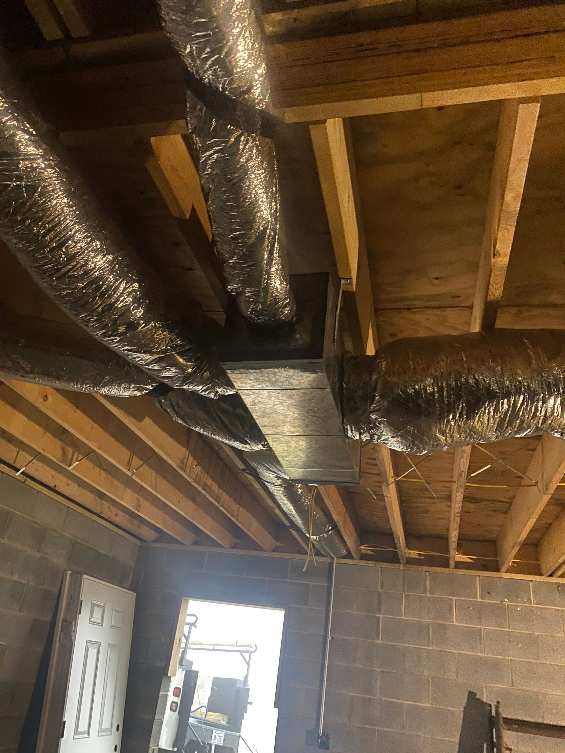 A bunch of ducts are hanging from the ceiling of a building.