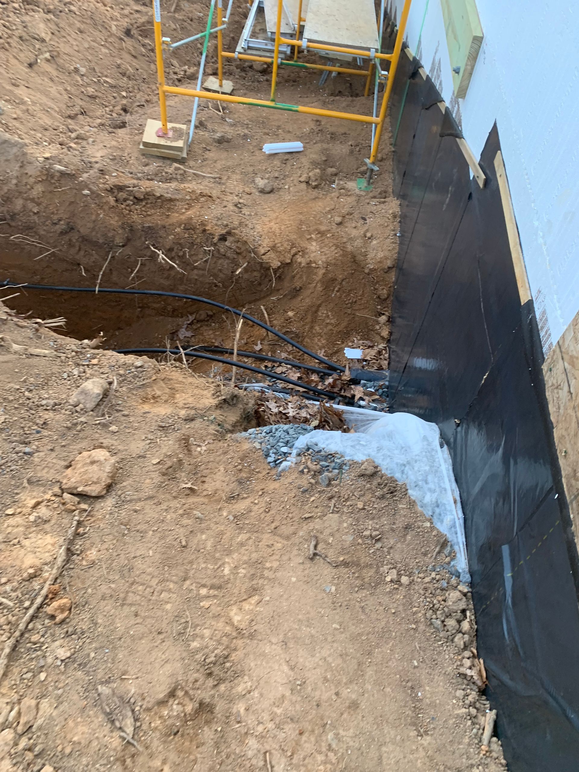 A hole in the ground with a scaffolding in the background.