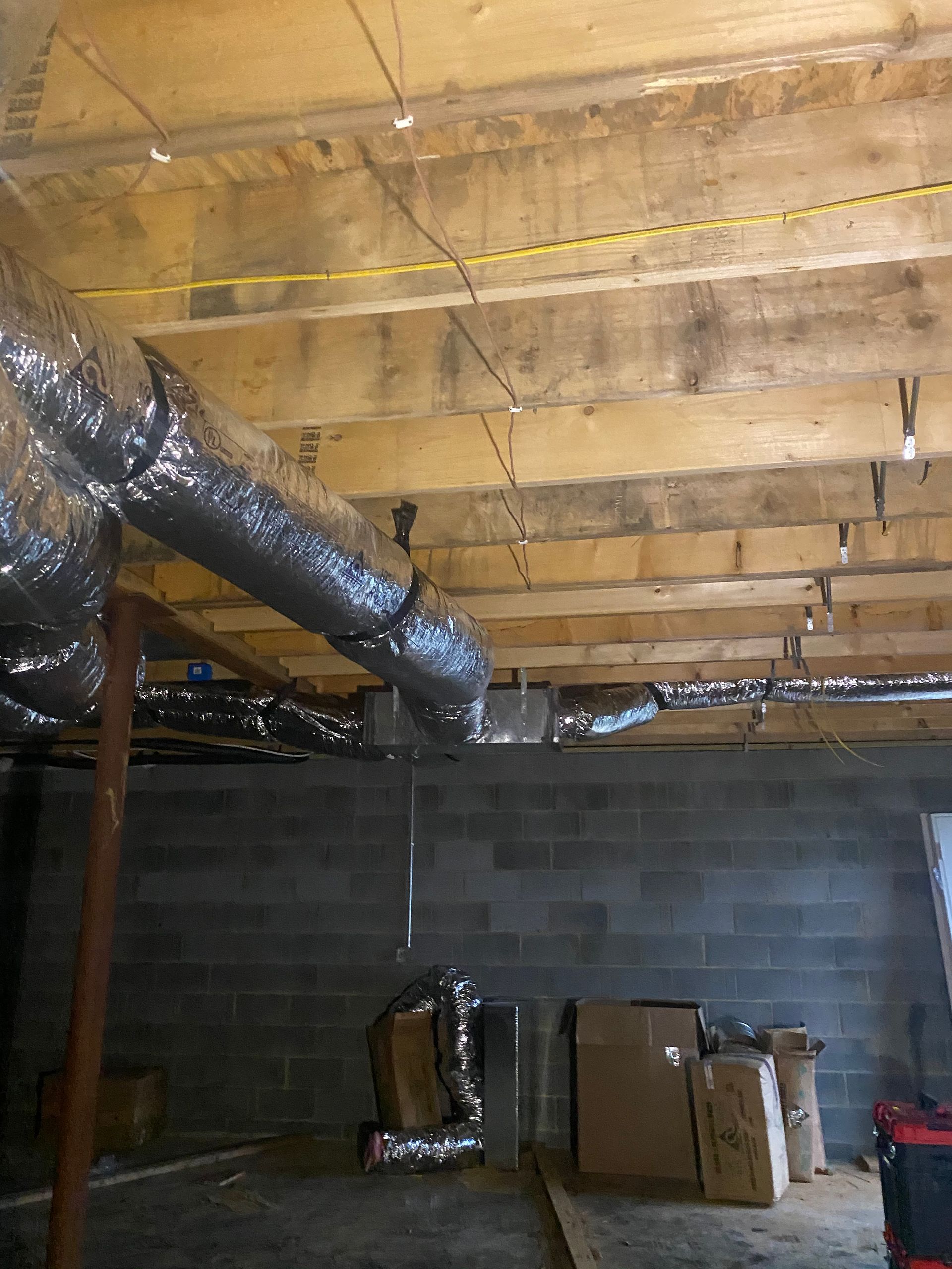 A basement with a lot of pipes coming out of the ceiling.