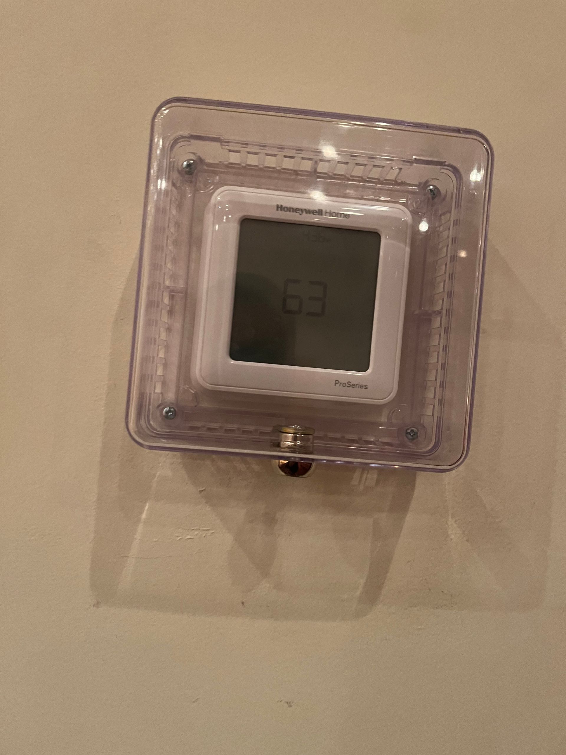 A digital clock is sitting on a white wall.