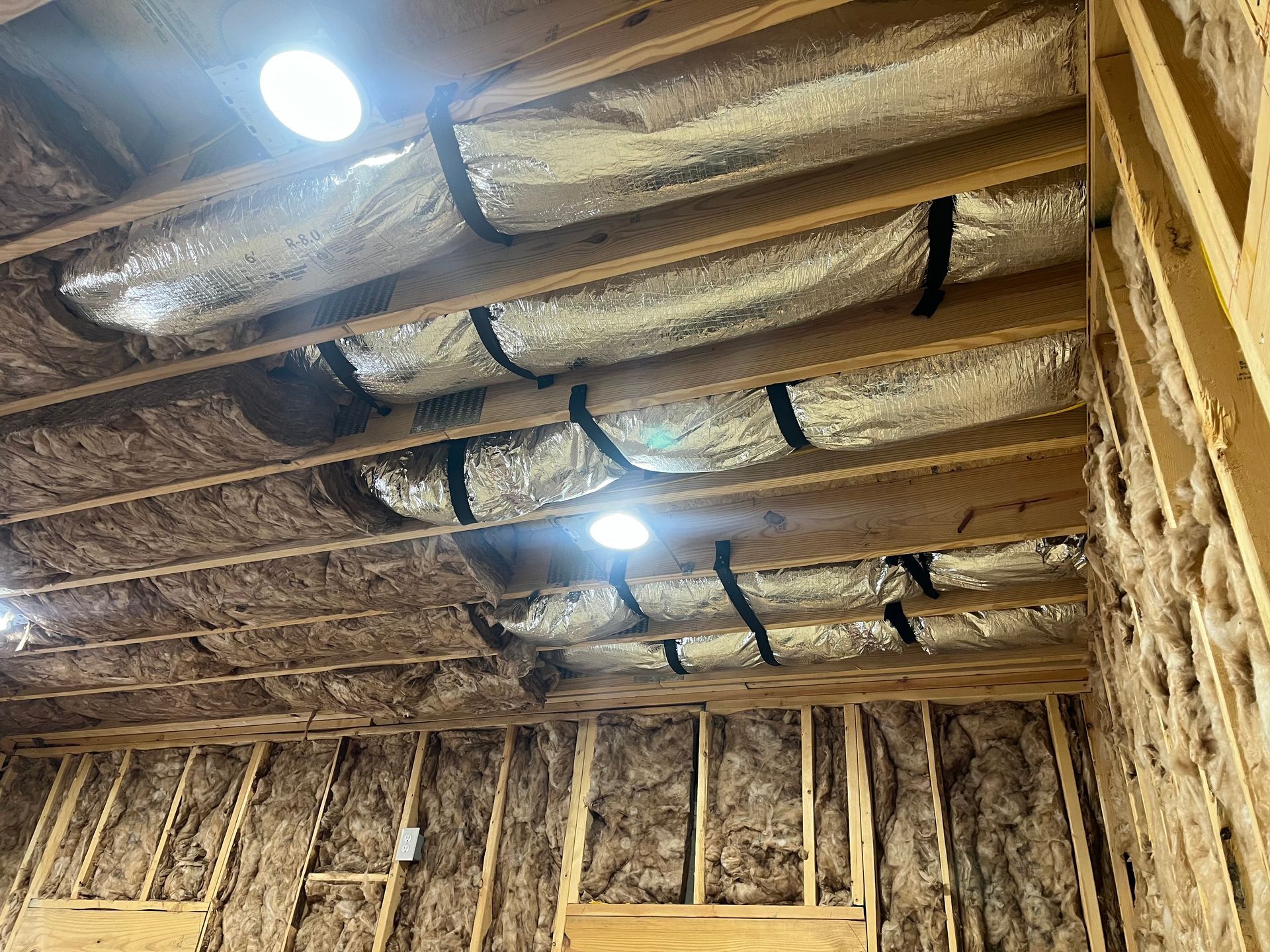 A room with a lot of ducts hanging from the ceiling.