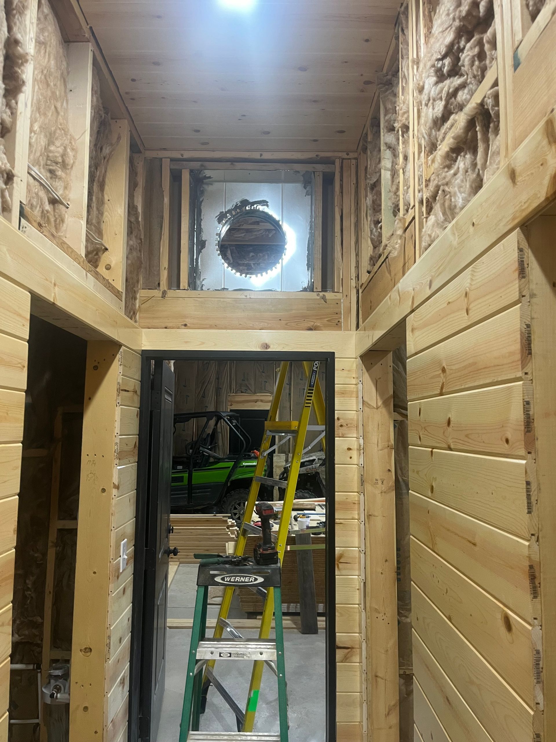 A wooden hallway with a ladder in the middle of it.
