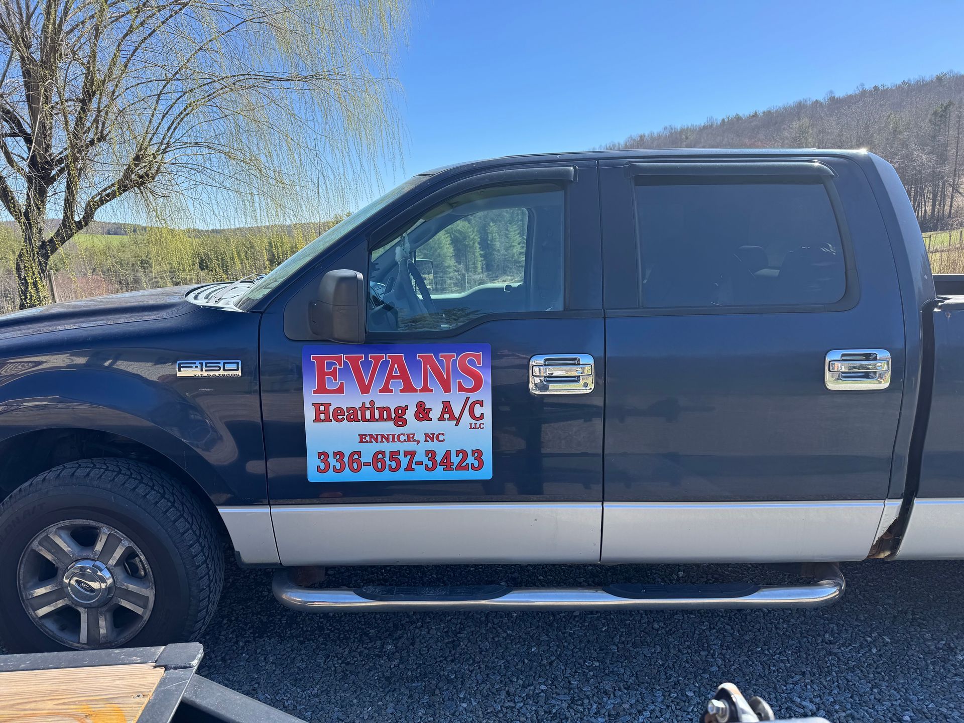 A black pickup truck is parked in a gravel lot.