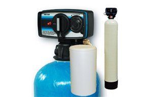 A blue water softener tank with a control valve and a white secondary filter tank standing beside it.