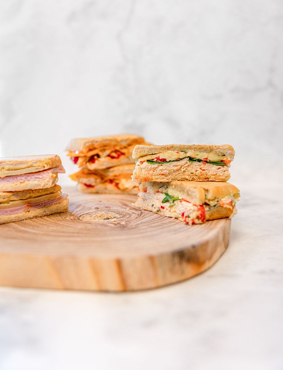 Three paninis on a wooden cutting board