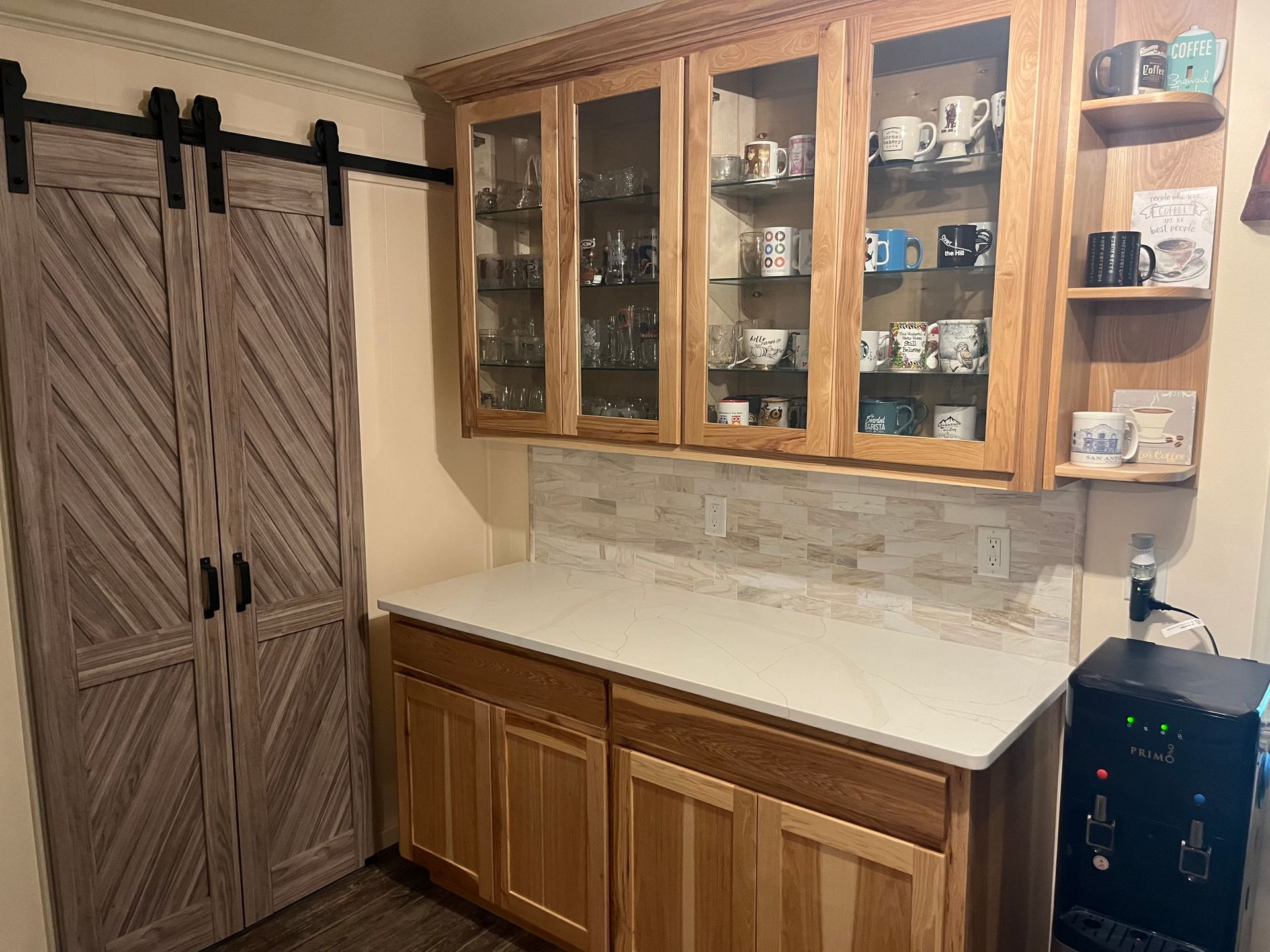Kitchen with wooden cabinets, countertop, barn door, and a water dispenser.