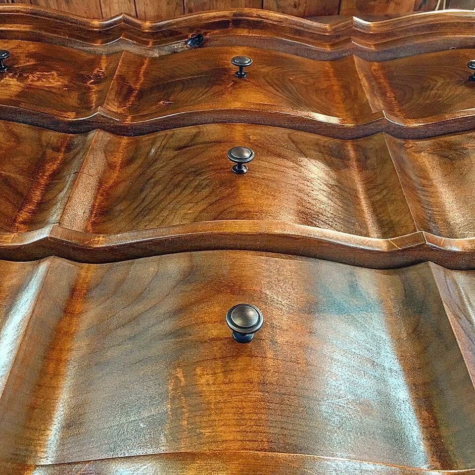 Wooden dresser with three curved drawers, each with a round knob.
