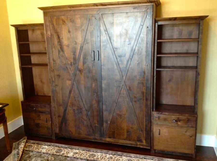 Wooden Murphy bed with two side bookshelves, a dark stain finish, and X-shaped door accents.