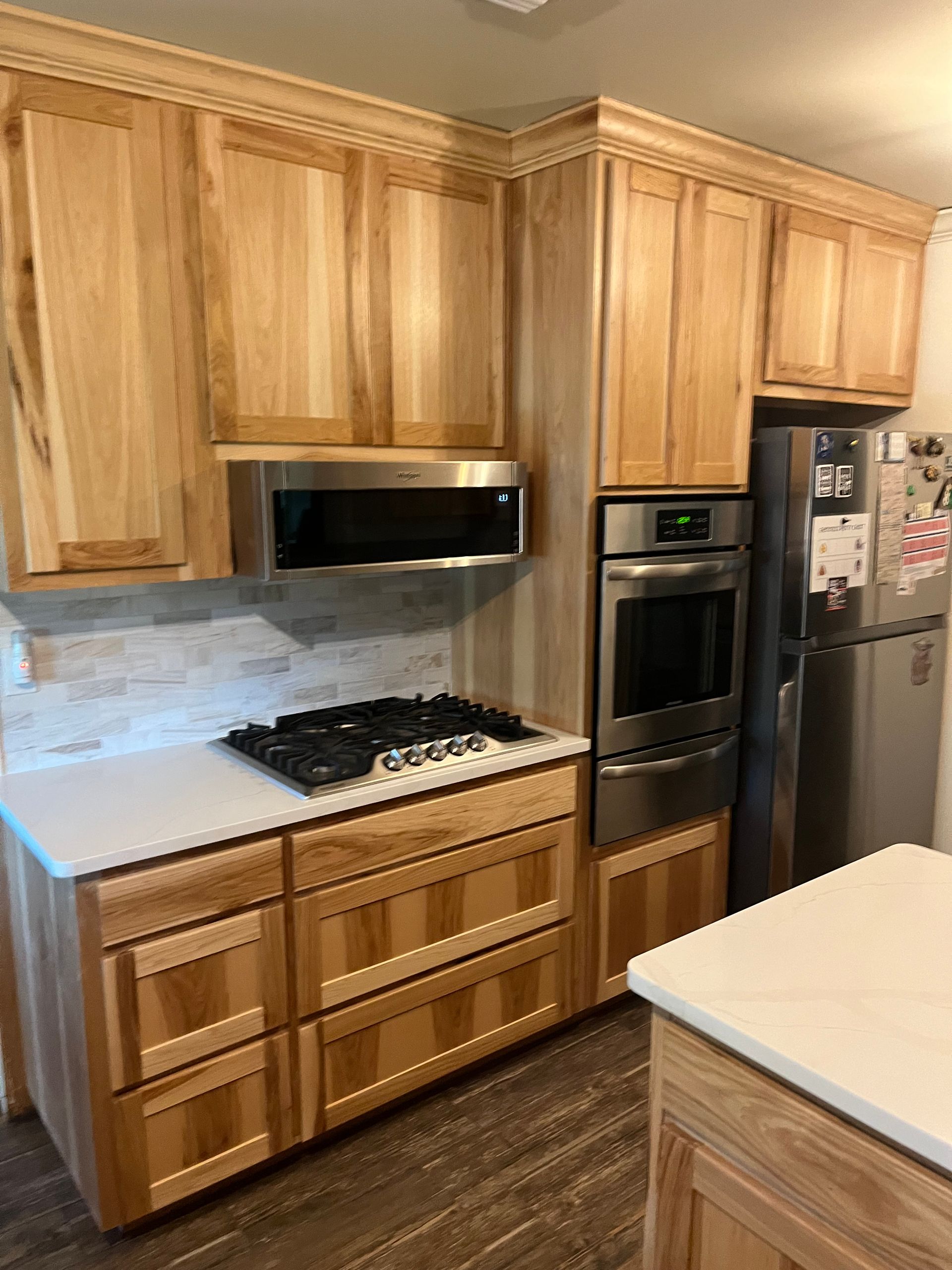 Kitchen with light wood cabinets, white countertops, stainless steel appliances, and a gas cooktop.
