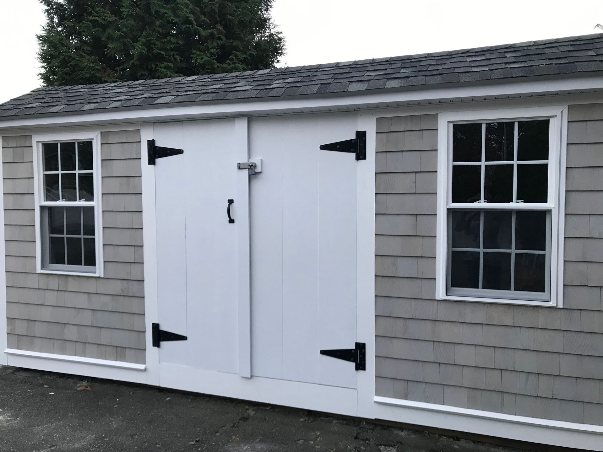 a shed with a white door and two windows